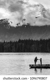 Black And White Scene Of A Father And Son Fishing On A Dock On The Lake