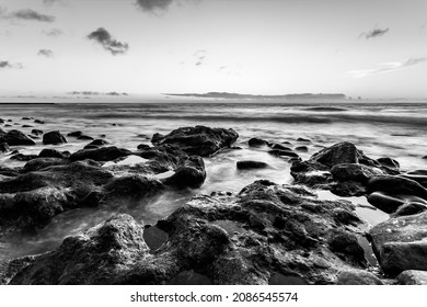 Black and white seascape with sunset over the Atlantic Ocean in Tenerife, Canary Islands, Spain. Long exposition, water in motion blur