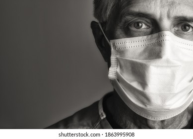 Black And White Sepia Closeup Portrait Of A Mature Male Doctor Wearing A Surgical Mask. Only Partial Face Is Seen With Copy Space.