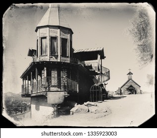 Black And White Sepia Vintage Photo Of Old Western Wooden Building/Brothel In Goldfield Gold Mine Ghost Town In Youngsberg, Arizona, USA Surrounded By Cactuses