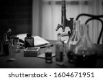 black and white shot of an 1885 scientist labratory. focus on brass microscope