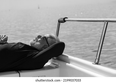 Black And White Shot Of Middle Aged Man With Cigarette Lying On His Boat; Pure Relaxation