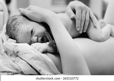 Black and white shot of newborn baby right after delivery 