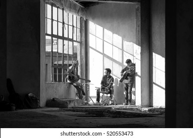 Black And White Shot Of A Rock Band Members Playing Music Indoor.