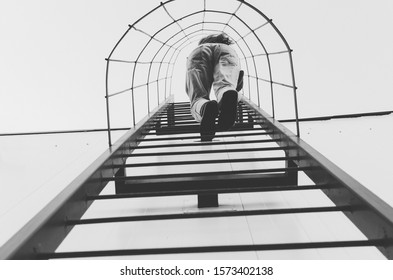 Black And White Shot Of Woman Climbing Ladder On A Roof