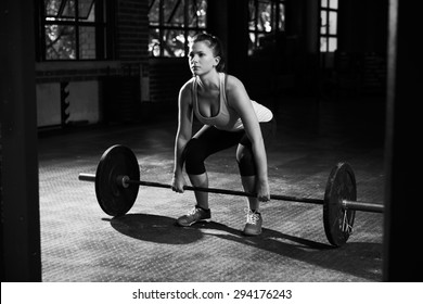 Black And White Shot Of Woman Preparing To Lift Weights