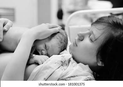 Black and white shot of young woman with newborn baby right after delivery - Powered by Shutterstock