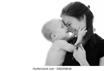 Black And White Side Portrait Of Young Woman With Long Hair Holding Little Baby, Baby And Mother Laughing. Family Love, Tenderness And Sincerity, Closeup