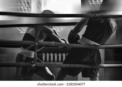 Black and white silhouettes of boxing athletes in the ring. Combat sports. Shallow depth of field. Motion blur effect.