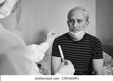 Black And White Snapshot Of Doctor's Visit At Home. Nurse Taking Coronavirus Test Analysis With Medical Swab To Elderly Male Patient. Test Tube For Taking OP NP Patient Specimen Sample.