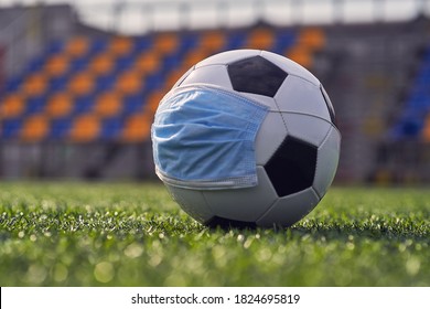  Black and White Soccer Ball In  Medical Mask On  Background of  Empty Seats of  Stadium. Football Competitions During Quarantine Time. COVID-19 Concept                 - Powered by Shutterstock