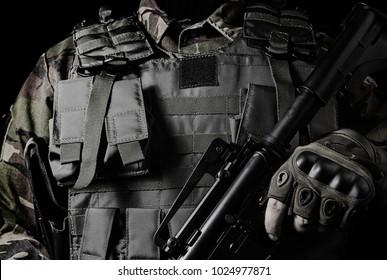 Black and white soldier closeup outfit. Black and white closeup photo of a soldier in military outfit with weapon on black background.