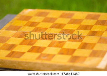 Black and white squares on a wooden chessboard for the game