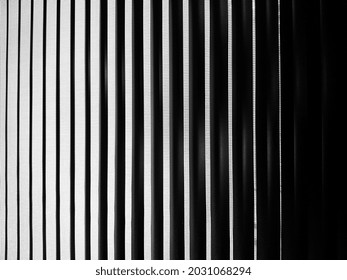 Black and white stripe curtain with light and shadow background in vertical lines.