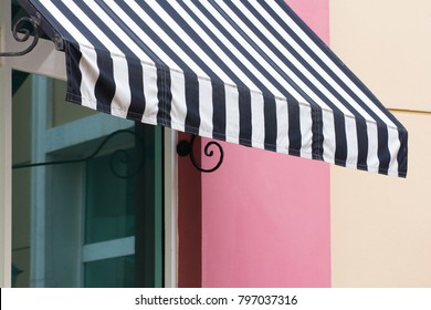 Black And White Striped Awning Over Glass Window Of Restaurant