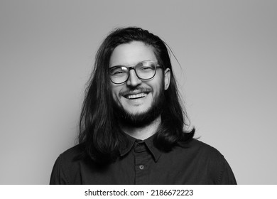 Black And White Studio Portrait Of Happiness Man With Long Hair, Smiling, Wearing Eyeglasses.