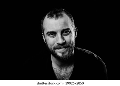 Black And White Studio Portrait Of Young Caucasian Man With Beard And Moustache Wearing Black T-shirt, Happy And Kind Face Expression, Smiling Look