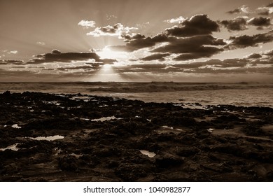 A Black And White Sunrise Over A Rocky Florida Beach