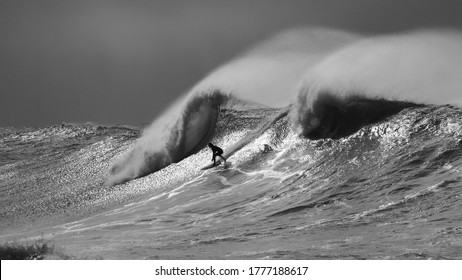 Black and white surfer riding in big waves