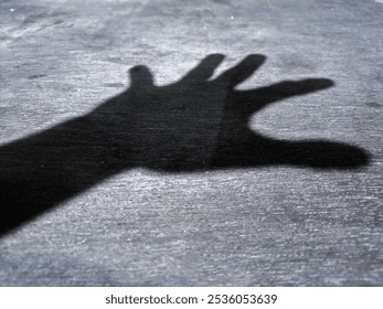 Black and white theme Hand Shadow. Light,shadow creates a dramatic,intriguing visual effect, highlighting contours,shape of hand,creative projects, conceptual designs,hand gesture