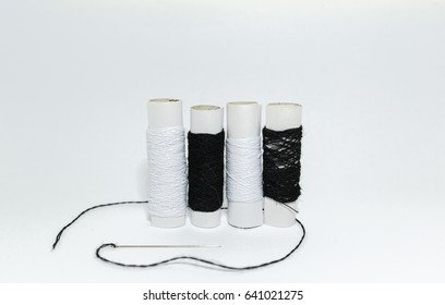 Black and white thread with sewing needle on white background