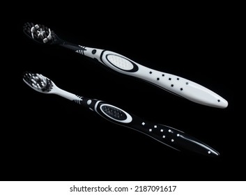 Black White Toothbrush Isolated On A Black Background.