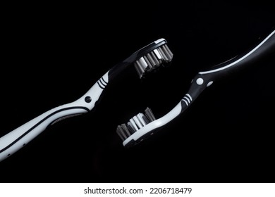 Black White Toothbrush Isolated On A Black Background.