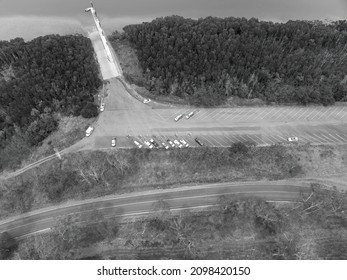 Black And White Top Down Drone Aerial Of Car Park On River With Boat Ramp And Bushy Banks