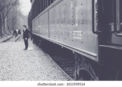 Black and White Train with Conductor Standing Nearby