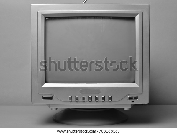 Black and\
white TV close-up on a wall\
background.