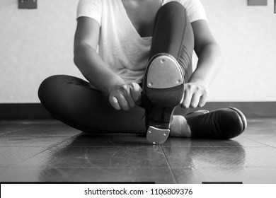 Black and white version of Tap dancer sliding on her tap shoes in the dance studio during dance class