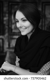 Black And White Vertical Portrait Of Young Beautiful Woman Indoor. The Girl Smiles And Does Not Look At The Camera.