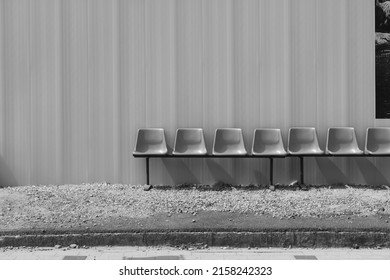 Black and white view of empty bus stop seats