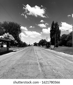 Black and white view of an empty road in a small town