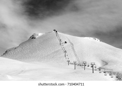 Black and white view on ski slope and chair-lift at sun winter morning. Caucasus Mountains. Georgia, region Gudauri, Mt. Kudebi.