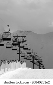 Black and white view on snowy skiing piste and ropeway. Caucasus Mountains. Georgia, region Gudauri in evening.