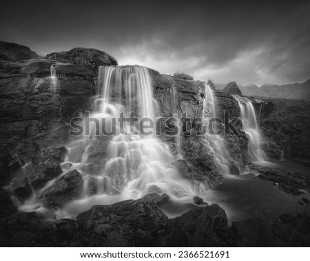 Black and white view of a waterfall on a mountain stream. Isle of Skye, Scottish Highlands, UK