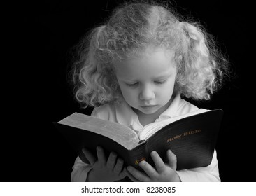 Black And White (with Color Accent) Image Of A Child Reading The Holy Bible.