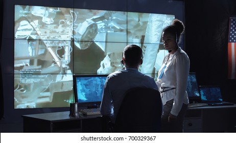 Black And White Woman And Man Monitoring In Dark Room Of Space Mission Control Center. Outer Works Of Astronauts. Elements Of This Image Furnished By NASA.