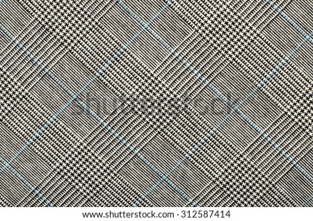 Black and white wool twill pattern. Black and white with blue houndstooth pattern in squares. Woven dogstooth check design as background.