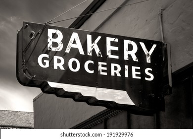 Black And White Worn Bakery And Groceries Sign In Small Town