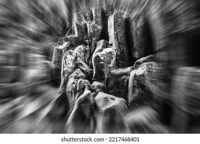 A Black And White, Zoom Blur Photo Of Moss Covered Volcanic Rocks In A Scenic River Gorge.