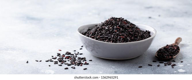 Black wild rice in a bowl. Grey stone background. 
