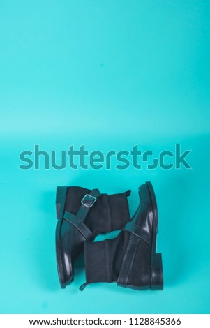 Black winter boots on a blue background. Autumn shoes on a colored background. Spring shoes with high heels on a turquoise background. Demi-season shoes