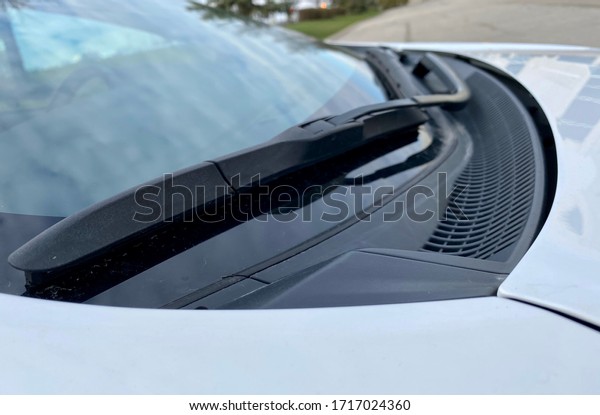 Black Wiper on car windshield. White car black\
windshield wiper.