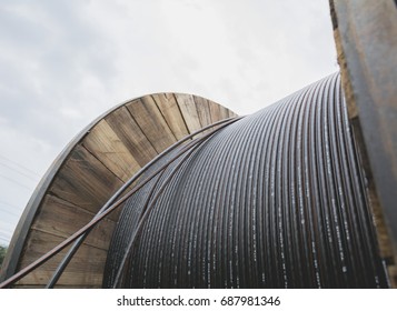 Black Wire  Electric Cable With Wooden Coil Of Electric Cable Under The Sky.