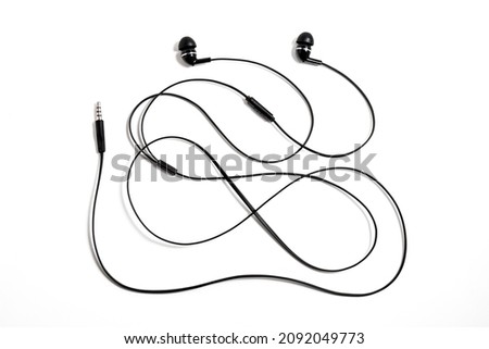 Black wired vacuum earplugs isolated on a white background. Headphones headset. In-ear headphones for listening music and sounds on portable devices.