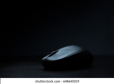black wireless computer mouse on dark background