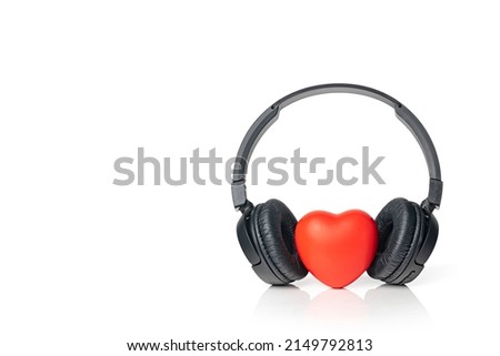 Black wireless headphones with red heart isolated on white background. Listen to your heart music of love. Copy space.