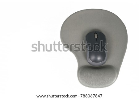 Black wireless mouse placed on gray mouse pad with gel wrist support on white background.